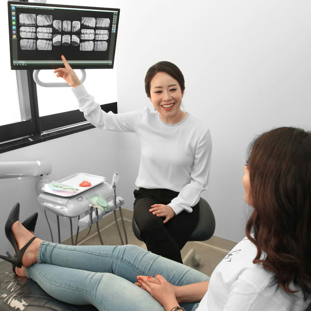 Dr. Min Hee Oh reviewing dental X-rays with a patient in Los Angeles
